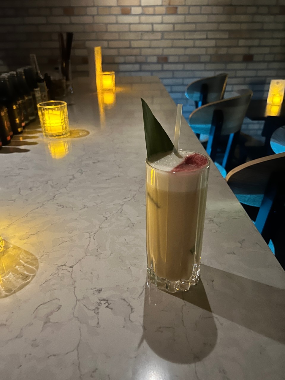 A cocktail placed on an empty bar with mood lighting